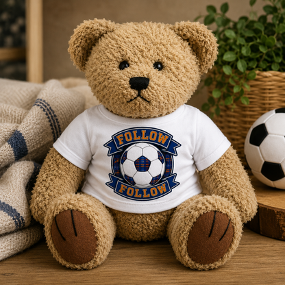 FOLLOW FOLLOW teddy bear displayed in a cosy nursery-style setting beside a football and soft furnishings.
