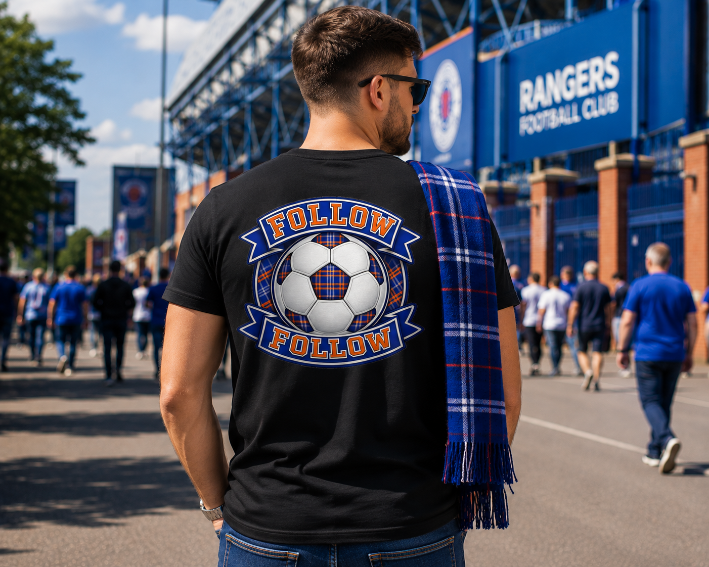 Man wearing a black FOLLOW FOLLOW men's t-shirt with a large football-inspired back print while walking toward a stadium on match day.