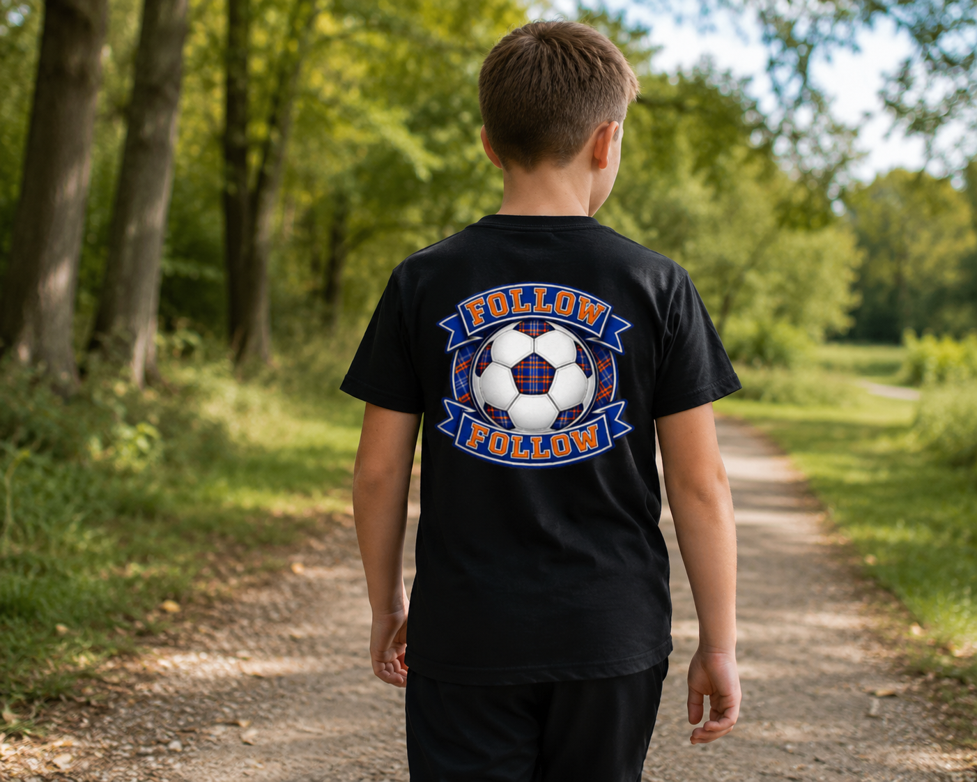 Child wearing a black FOLLOW FOLLOW youth t-shirt with a large football-inspired back print while walking along a woodland path.