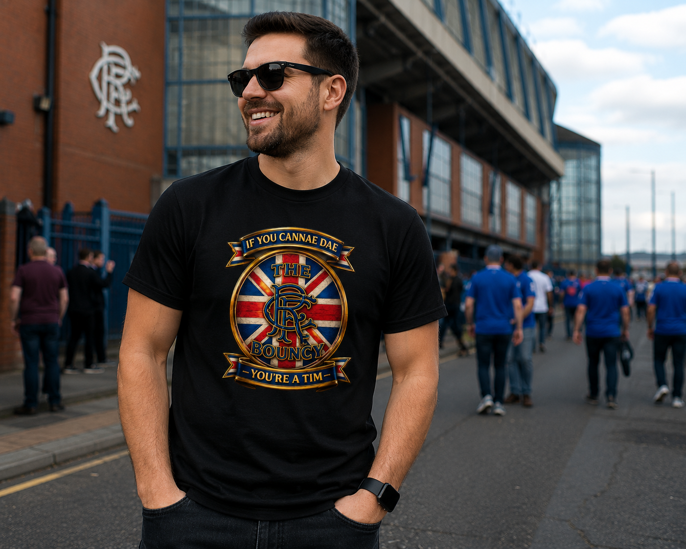 Man wearing the If You Cannae Dae The Bouncy men's T-shirt outdoors on matchday, featuring a bold Union Flag crest design.