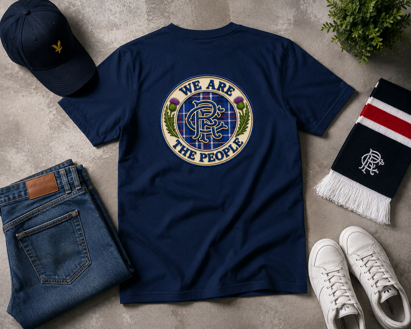 Navy We Are The People Crest back print t-shirt displayed in a flat lay arrangement with jeans, trainers, cap and scarf.