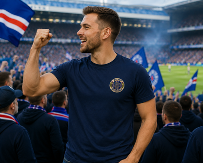 Football supporter wearing a navy We Are The People Crest men's t-shirt at a stadium featuring a small left chest badge design.