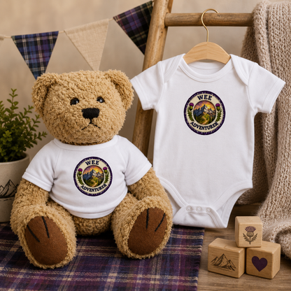 Wee Adventurer Teddy Bear beside matching Wee Adventurer baby bodysuit gift set in a Scottish-inspired nursery scene