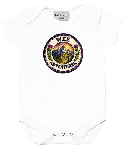 Wee Adventurer baby bodysuit featuring a Scottish mountain badge design with tartan detailing and thistle artwork.